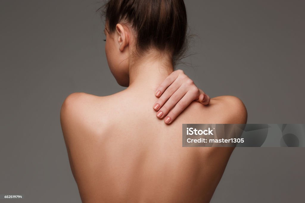 The beautiful woman's body on gray background The woman's body. nude woman back on gray Rear View Stock Photo