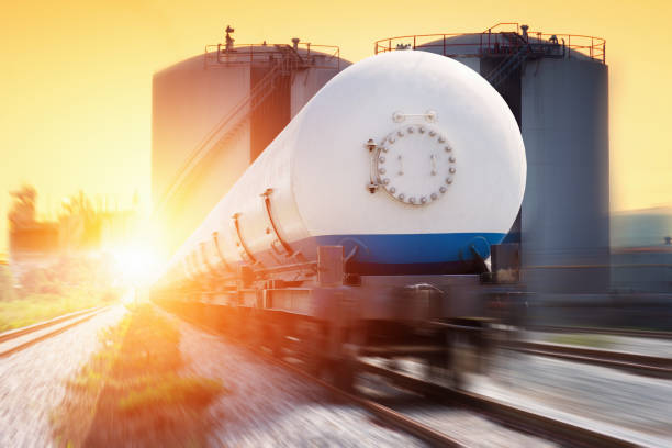 Tanks with gas being transported by rail at sunset Tanks with gas being transported by rail at sunset lng liquid natural gas stock pictures, royalty-free photos & images