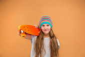 Pretty skater girl holding skateboard