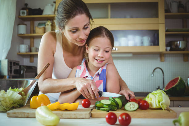 istock Mother and daughter preparing salad 652520908