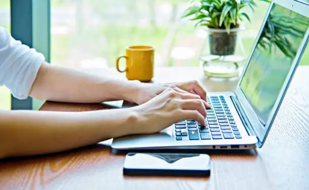 Photo of Woman hand typing on laptop