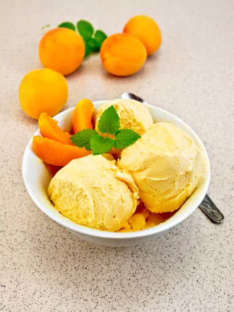 istock Ice cream apricot in white bowl on table with spoon 652553060