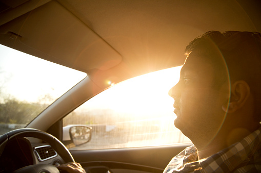 Silhouette of mid adult man driving the car