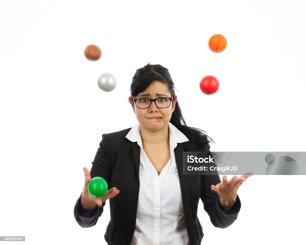 Juggling Business Issues Businesswoman juggling all of life's issues. She has many balls in the air. Studio shot on a white background. Juggling Stock Photo