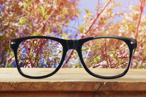 istock hipster glasses on a wooden table in front of cherry tree 652580048