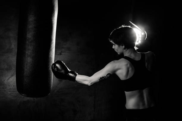 Athlete boxer woman punching a punching bag
