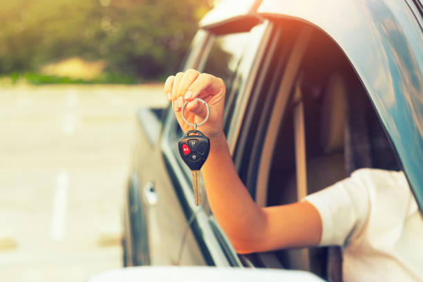 Cae key Woman's hand holding car key. car ownership photos stock pictures, royalty-free photos & images