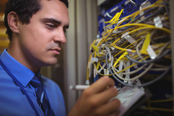 istock Technician maintaining record of rack mounted server on clipboard 652595148