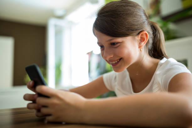 istock Girl using mobile phone in the living room 652605262
