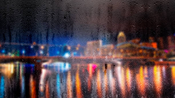 gotas de lluvia en la ventana con defocused edificios en el fondo - london england thames river storm rain fotografías e imágenes de stock