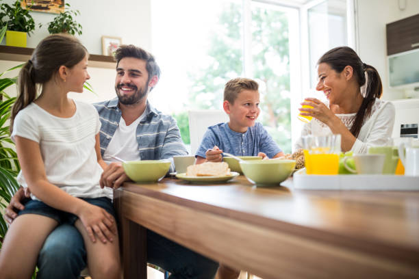 famiglia felice avendo colazione - juice glass healthy eating healthy lifestyle foto e immagini stock