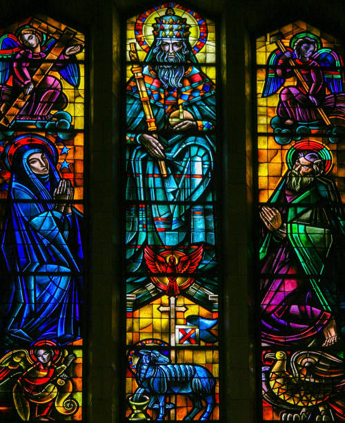 Stained Glass in Koekelberg, Brussels Stained Glass in Koekelberg Basilica, Brussels, depicting God, the Holy Spirit, Jesus personified by the Agnus Dei, Joseph and Mary. agnus dei stock pictures, royalty-free photos & images