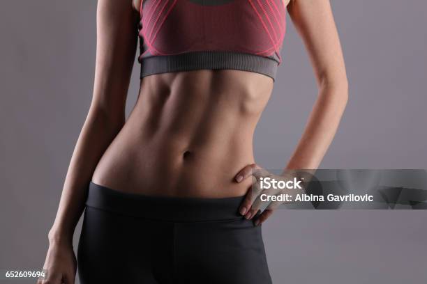 Sport Fit Woman Female With Perfect Abdomen Muscles On Grey Background Dieting Fitness Active Lifestyle Concept Copy Space Stock Photo - Download Image Now