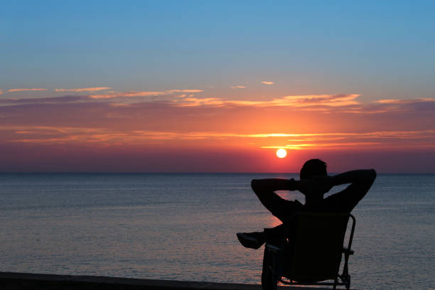 istock Young man relaxing in the beach on sunset 652613946