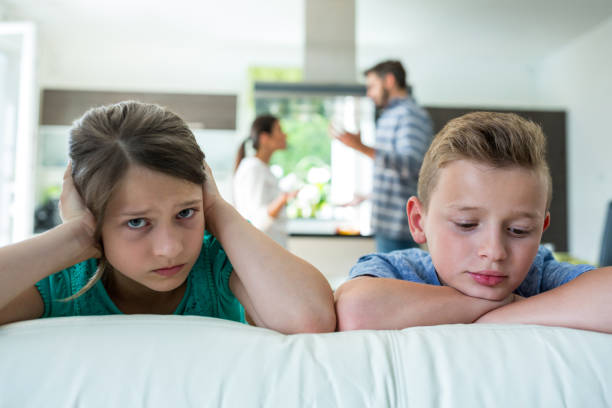 istock Sad kids leaning on sofa while parents arguing in background 652619728