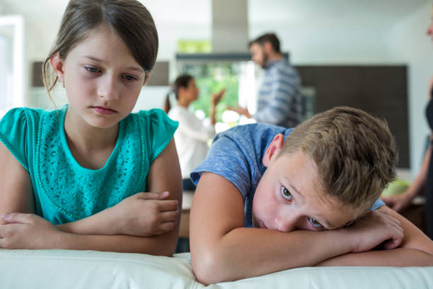 istock Sad kids leaning on sofa while parents arguing in background 652619736