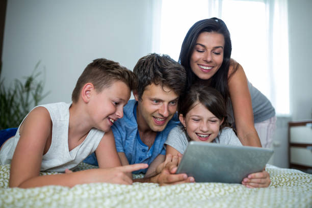 istock Happy family using digital tablet in bedroom 652620706