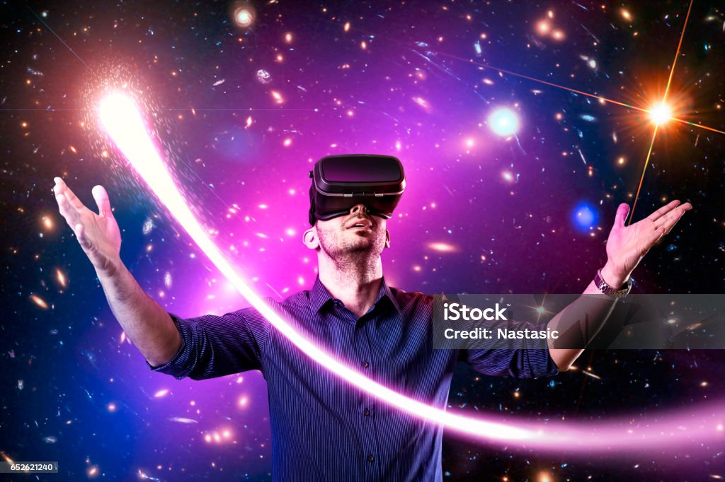 Man using virtual reality headset with Man in casual clothing using virtual reality headset with universe ,planets ,comet program application Virtual Reality Simulator Stock Photo