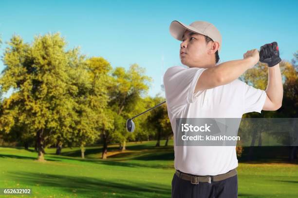 Smiling Asian Chinese Man Swinging Golf Club Stock Photo - Download Image Now - 40-49 Years, Active Lifestyle, Adult