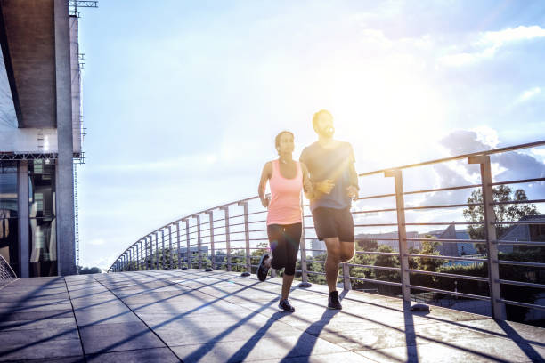 istock woman and man jogging over berlin bridge at sunset 652632302