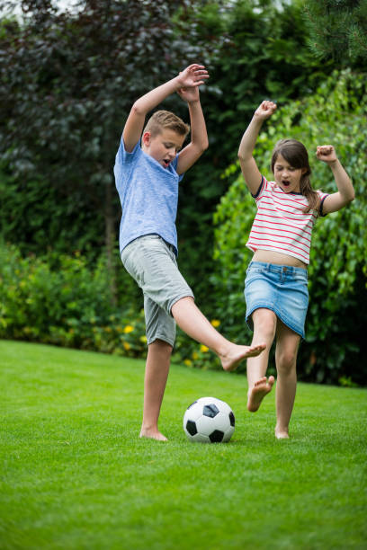 istock Kids playing with football in park 652633016