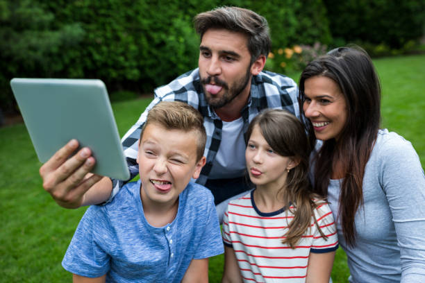 istock Happy family taking a selfie from digital tablet in park 652636142