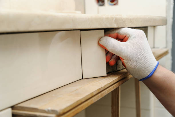 istock Worker's hand puts the piece of tile. 652641506