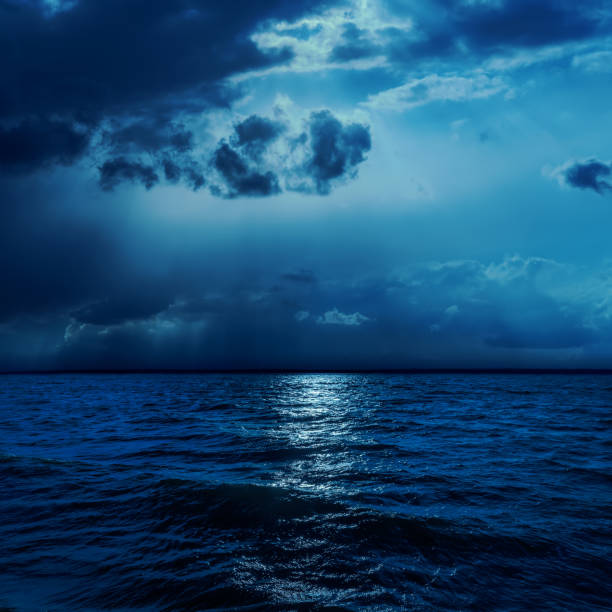 istock dark clouds in night with moonlights over water 652655612