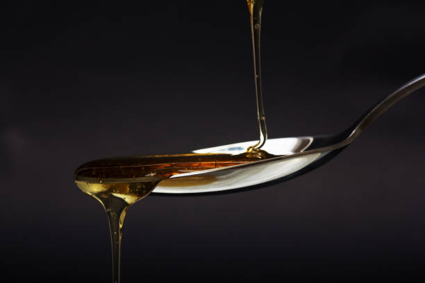 istock Honey pouring from spoon against a dark background 652659904