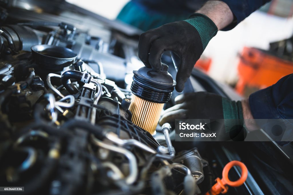 Auto mechanic service and repair Close up hands of unrecognizable mechanic doing car service and maintenance. Oil and fuel filter changing. Car Stock Photo