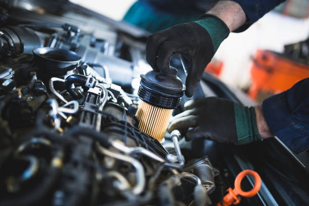 Auto mechanic service and repair Close up hands of unrecognizable mechanic doing car service and maintenance. Oil and fuel filter changing. vehicle part stock pictures, royalty-free photos & images