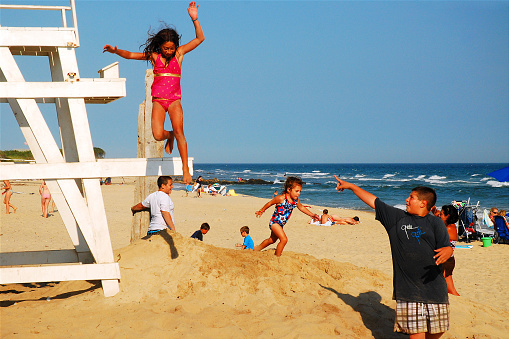 Montauk, NY, USA July 27, 2010 A young girl jumps from a lifeguard chair at Ditch Plains Beach in Montauk, New York