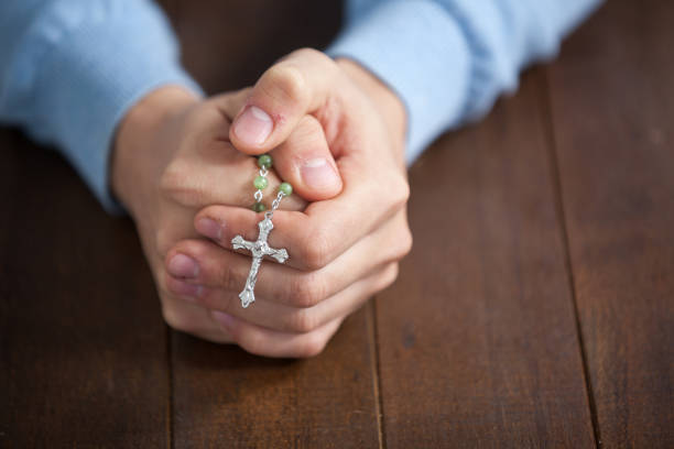 istock Praying hands of man with a rosary 652670530