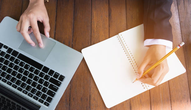 istock Top view business woman write on notebook and use laptop. 652681570