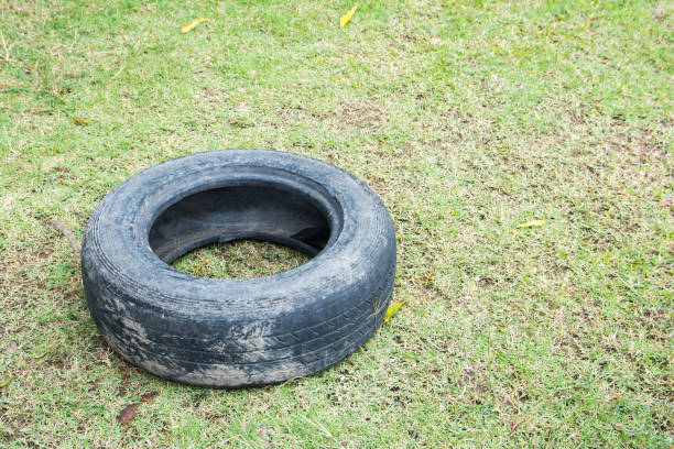 vecchie gomme sull'erba. vecchio pneumatico - tire recycling recycling symbol transportation foto e immagini stock