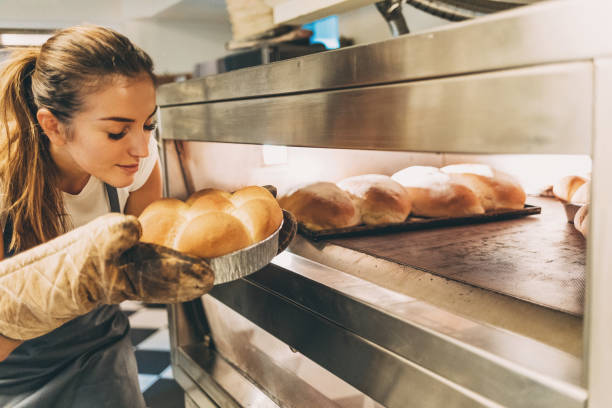 disfrutando el olor del pan caliente fresco - smelling bread bakery women fotografías e imágenes de stock