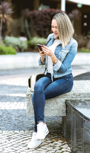 istock Beautiful young woman in real life using smartphone 652725658