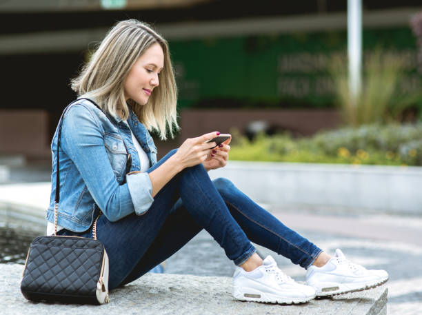 istock Beautiful young woman in real life using smartphone 652725694