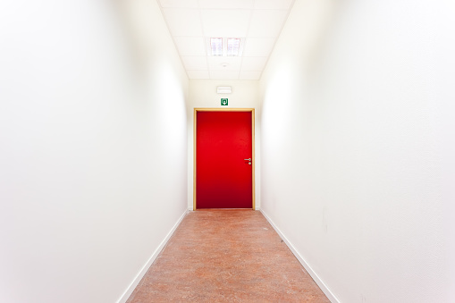 in a building, there is a corridor with an emergency exit