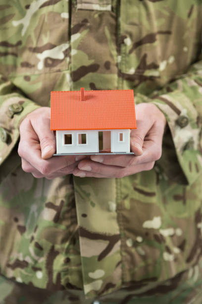 istock Mid section of soldier holding a model home 652764694