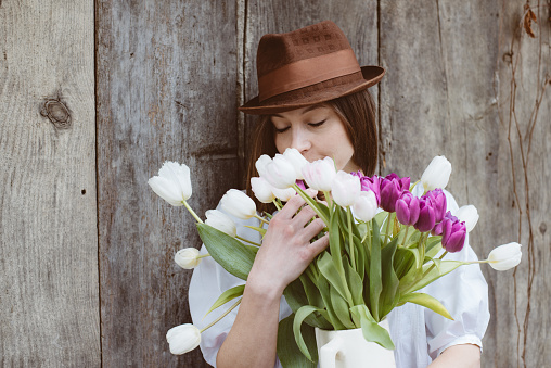 Cute brunette female with bunch of tulip flowers, easter concept