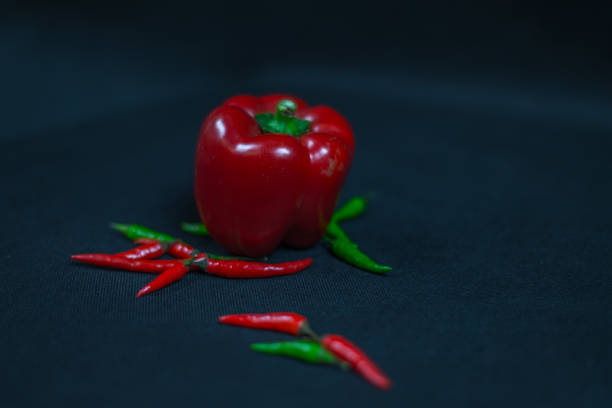 artistic decoration with fresh small red, green peppers and two bells pepper, fresh vegetables, chili peppers, spicy and hot