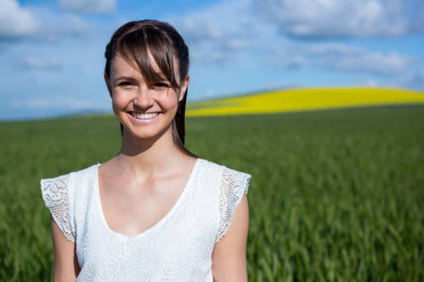 istock Happy young woman standing in field 652799436