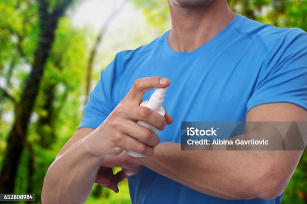 Mosquito Repellent Male Using Insect Repellent Spray From Bootle In Forest Stock Photo - Download Image Now