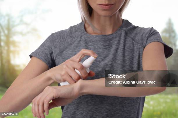 Woman Spraying Insect Repellent On Skin Outdoor Stock Photo - Download Image Now - Spraying, Spray, Insect Repellant