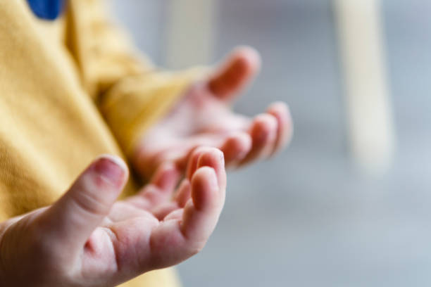 istock little child hands - kid, yellow shirt 652815732