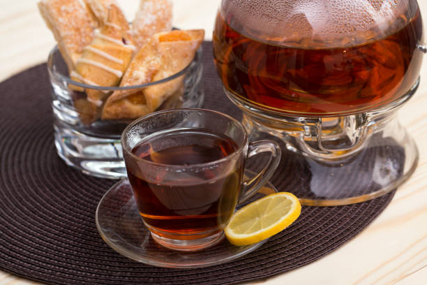 istock Cup of tea with lemon and cake on glass tableware 652822478