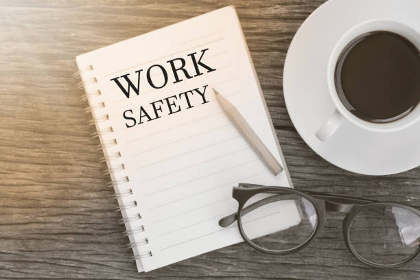 istock Concept Work safety message on notebook with glasses, pencil and coffee cup on wooden table. 652822762