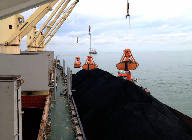 mechanical hydraulic grabbers loading coal by ship cranes stock photo