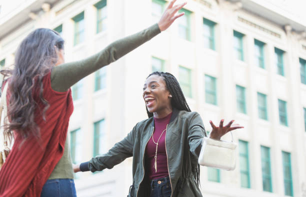 Two young women embracing on street corner